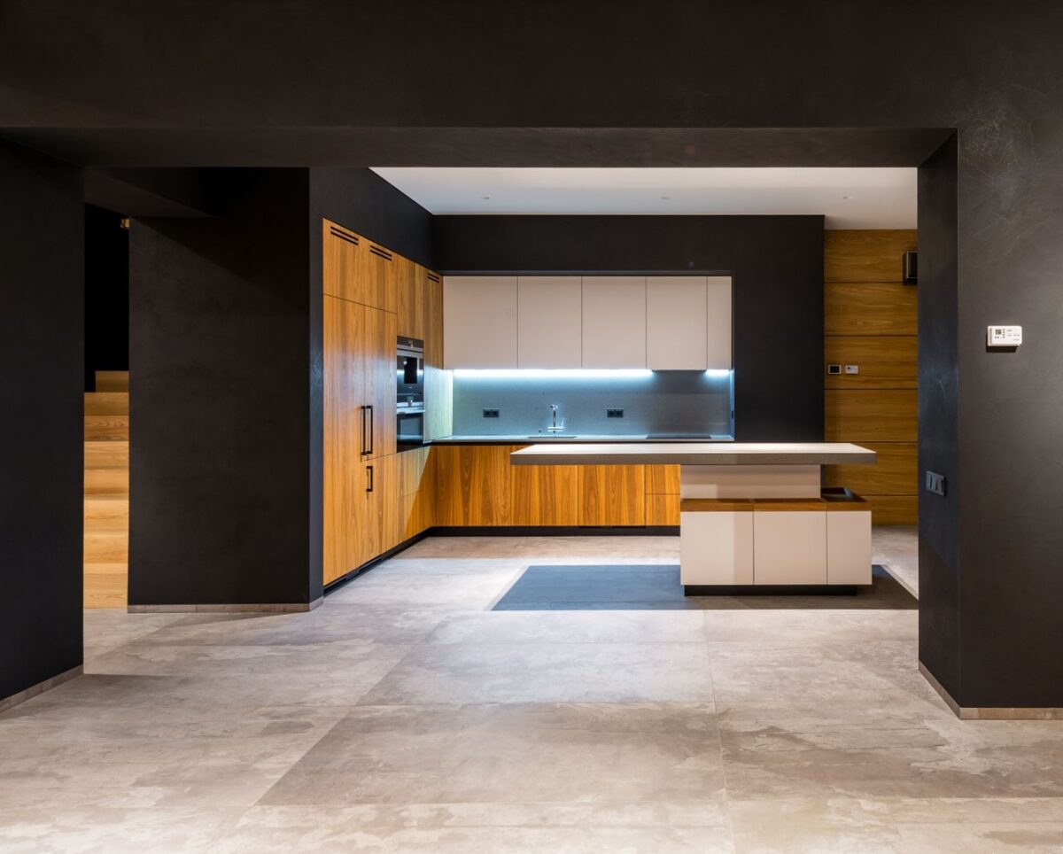 À propos Interior of modern cottage with marble floor and spacious kitchen with wooden furniture and floating tabletop